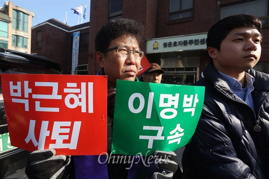 기자회견 참석자들이 '박근혜 사퇴' '이명박 구속'이 적힌 손 피켓을 들고 있다.