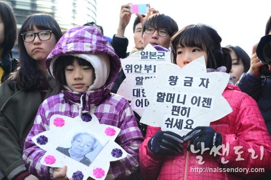 1월 29일, 일본대사관 앞에서 진행된 일본군 '위안부' 문제 해결을 위한 1111차 정기수요집회에서 참가자들이 고 황금자 할머니를 기리는 피켓을 들고 있다.