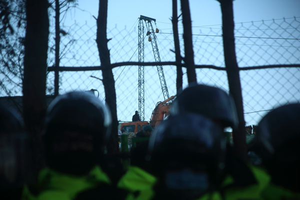 건설현장을 지키는 경찰들 뒤로 97번 송전탑이 보인다. 