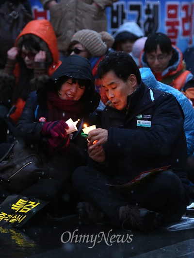 노동자들이 '촛불'을 옆으로 이어붙이고 있다.