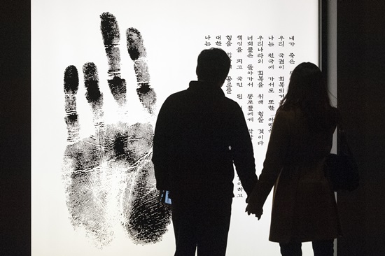 발렌타인 데이이자 안중근 의사가 사형선고를 받은 14일 오전 서울 중구 안중근기념관을 찾은 한 연인이 손을 잡고 '단지' 그림을 보고 있다.