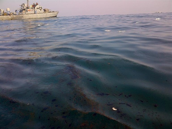 부산환경운동연합은 부산 앞바다에서 발생한 기름유출사고는 인재라고 밝혔다. 사진은 사고선박에서 유출된 기름띠와 방제작업 중인 해군함정