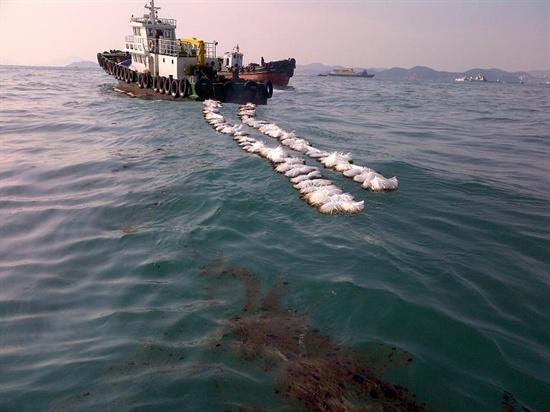 부산환경운동연합은 부산 앞바다에서 발생한 기름유출사고는 인재라고 밝혔다. 사진은 사고선박에서 유출된 기름을 흡착띠로 흡착하는 모습.