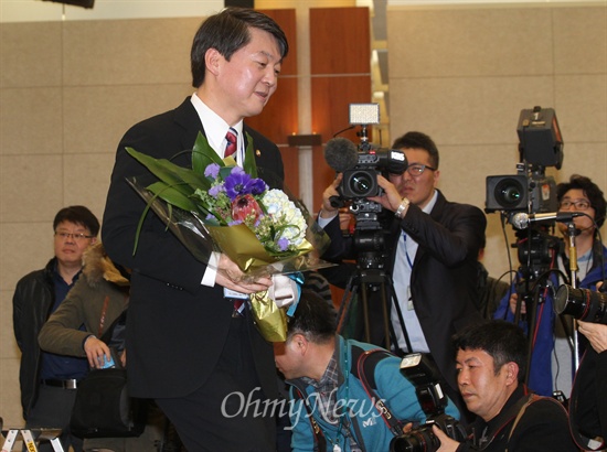 17일 오후 서울 용산구 백범김구기념관에서 열린 '새정치연합' 창당 발기인 대회에서 중앙운영위원장으로 선출된 안철수 의원이 발기인으로부터 축하꽃다발을 건네받고 제자리로 향하고 있다.