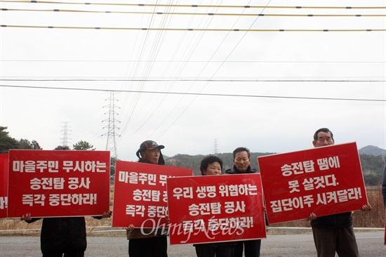 봉두마을 주민들이 18일 마을 입구에 마련된 봉두마을송전탑반대대책위원회 사무실 앞에서 피켓을 들고 송전탑 공사 반대 시위를 하고 있다. 
