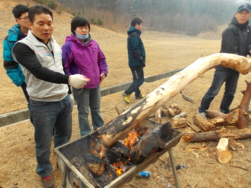 장승 장승의 밑둥을 불로 그슬리고 있다. 밑둥은 흙 속으로 들어가기 때문에 쉽게 부식될 수 있다. 그래서 목질의 내구성을 강화시킬 목적으로 밑둥 부분을 불로 그슬린다. 사진 중앙에 마스크를 쓰고 있는 사람이 한준혜 공주민주단체협의회 집행위원장이다.  