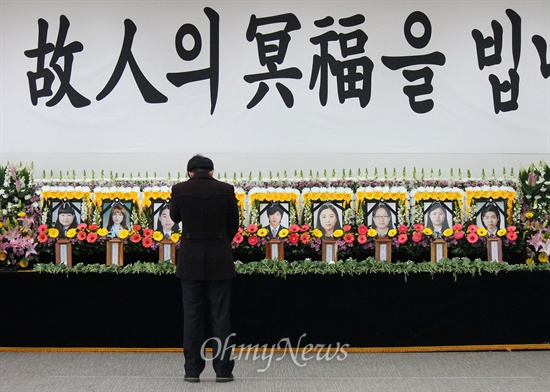  지난 2월 경주 마우나오션리조트 사고 당시 희생학생들의 합동분향소가 마련된 부산외대에서 한 조문객이 학생들을 추모하고 있다.