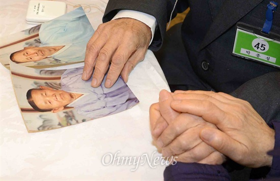 2014 설 계기 2차 이산가족상봉이 열린 23일 북한 금강산 면회소에서 동생 박종분, 박종욱, 박종순(남측) 할머니가 오빠 박종성(87, 북측) 할아버지를 만나 오래전 돌아가신 부모님 사진을 보고 있다.