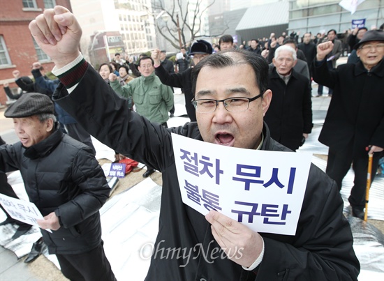  안전행정부가 대선 당시 박근혜 후보 지지선언을 했던 박상증 목사를 민주화운동기념사업회 이사장으로 임명한 가운데 25일 오후 서울 정동 배재정동빌딩 앞에서 '민주화운동기념사업회 이사장 불법임명 거부대책위' 회원들이 박상증 목사의 자진 사퇴를 촉구하는 집회를 열고 구호를 외치고 있다.