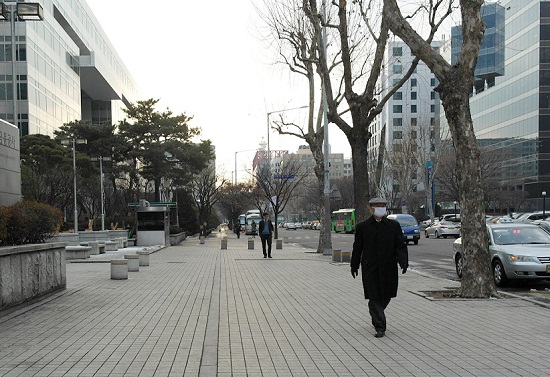서울 여의도 일대에 미세먼지가 다소 껴있는 가운데 한 시민이 마스크를 쓰고 걷고 있다.