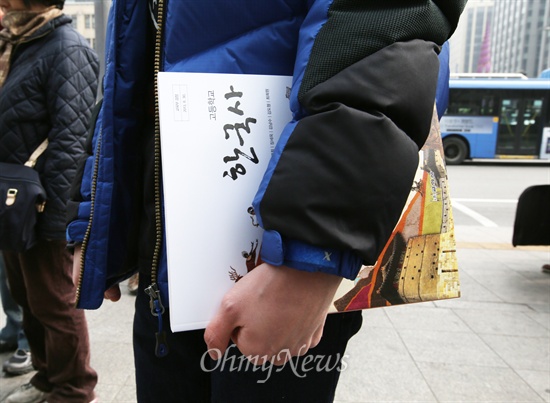 1일 오전 서울 중구 동화면세점 앞에서 열린 '바른역사독립을위한시민대회'에서 판매된 교학사 역사교과서를 한 참가자가 들고 있다.
