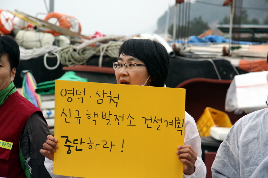 환경정의 활동가가 영덕 핵발전소 철회를 요구하는 피켓을 들고 있다. 