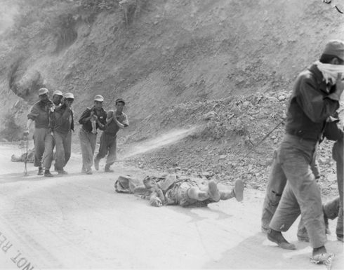 한국전쟁 중 적군의 시신을 밧줄로 끌어 모으고 있다.
