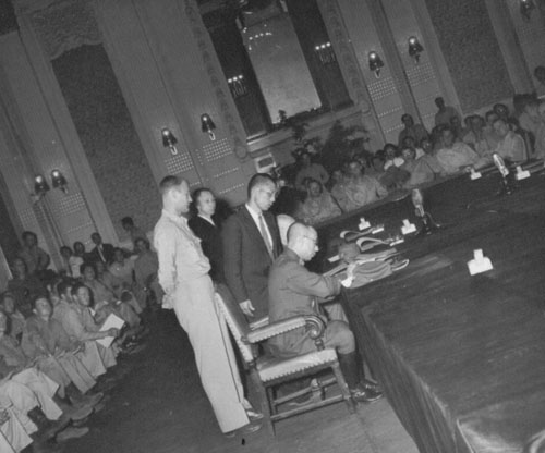미군이 지켜보는 가운데 조선총독부 제1회의실에서 총독부 관리가 항복문서에 서명하고 있다.