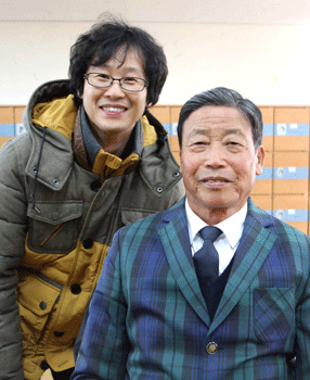  강태만씨가 교실에서 담임교사와 함께 사진을 찍고 있다. 