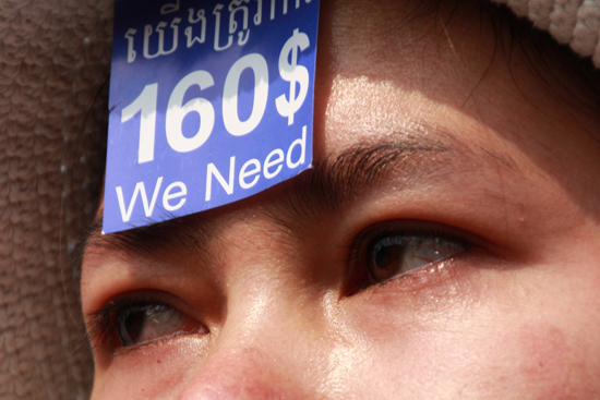 세계여성의 날을 기념하는 행사가 세계 곳곳에서 열린 지난 8일 캄보디아 수도 프놈펜 자유공원 집회현장을 찾은 봉제공장 근로여성이 "우리는 최저임금 160불이 필요하다"는 문구를 적힌 스티커를 이마에 붙인 채 눈물을 글썽이고 있다. 