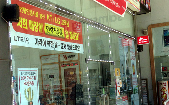 오는 13일부터 '단독 영업'을 앞둔 한 SK텔레콤 대리점 앞에 KT와 LG 고객에게 연락처를 등록하라는 현수막이 걸려있다. 
