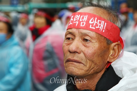 가로림만 갯벌 지키기 위해 머리띠 두른 노인  12일 오후 서울 중구 동화면세점 앞에서 해안과 갯벌 파괴를 이유로 가로림만 조력발전소 건립을 반대하는 지역주민과 환경단체들이 조력발전 사업 중단을 촉구하는 집회에서 한 참가자가 '조력댐 안돼' 머리띠를 두르고 있다.