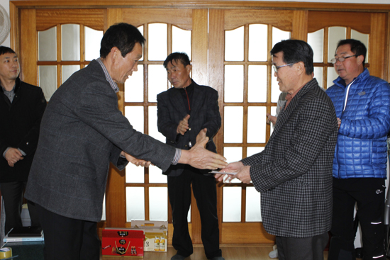 충남 태안군 인평1리의 박규준(왼쪽) 이장이 전창환 인평2리 이장에게 주민들의 정성이 모아진 성금 100만원을 전달하고 격려했다.
