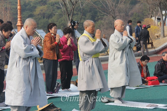  화쟁코리아 100일 순례단을 이끌고 있는 도법 스님 등이 18일 오전 창원 국립3.15묘지 참배를 마친 뒤 광장에서 '순례 창원지역 입재식'을 하며 절을 하고 있다.