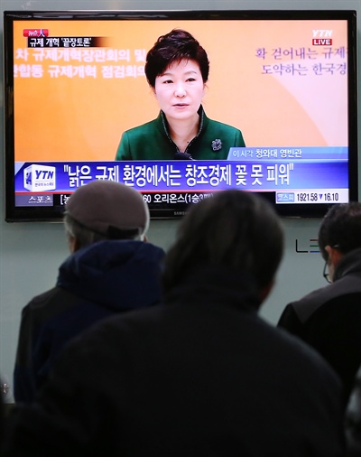 제1차 규제개혁장관회의 겸 민관합동 규제개혁점검회의가 열린 지난해 3월 20일 오후 서울역에서 시민이 박근혜 대통령의 모두발언을 시청하고 있다.