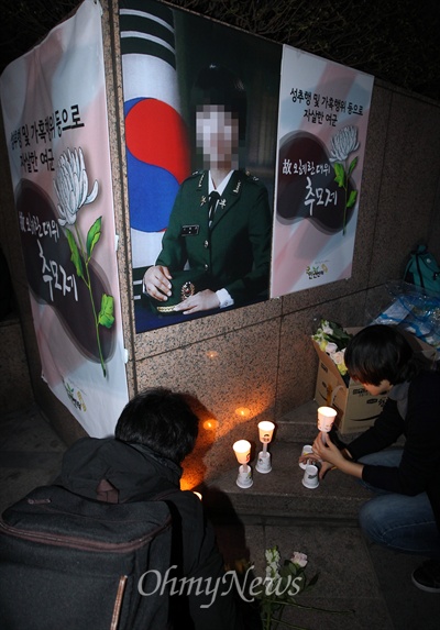 24일 오후 서울 중구 서울파이낸스센터 앞 광장에서 열린 '고 오혜란 대위 추모제'에서 시민들이 고인의 영정 앞에 촛불을 밝히고 있다.