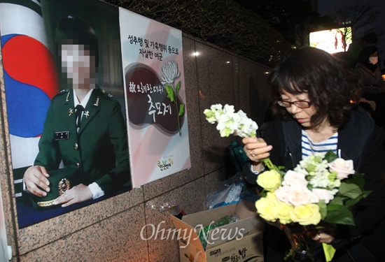 지난 3월 24일 오후 서울 중구 서울파이낸스센터 앞 광장에서 열린 '고 오혜란 대위 추모제'에 참가한 시민이 고인의 넋을 위로하며 헌화하고 있다.