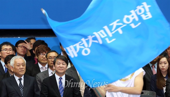 26일 오후 서울 송파구 올림픽공원 올림픽홀에서 열린 새정치민주연합 중앙당 창당대회에서 선출된 김한길-안철수 공동대표가 '새정치민주연합'이라고 적힌 깃발을 휘날리는 축하공연을 지켜보고 있다.