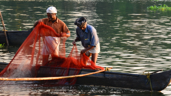 어부들이 즐거운 모습으로 그물을 당기고 있다.