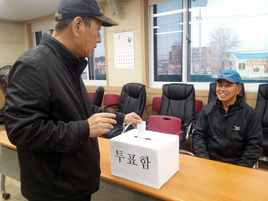 강릉 송정동 지역 후보단일화를 위해 선발된 선거인단 56명은 27일 송정동 주민센터 2층에 마련된 투표소에서 기표를 한 후 용지를 투표함에 넣고있다.  총 투표인단 56명중 75%인 42명이 투표에 참여했다. 