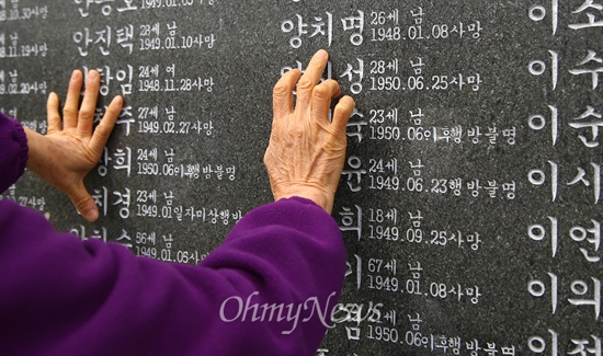 2014년 4월 3일 제주 4.3평화공원에서 희생자 유가족이 각명비에 세긴 가족의 이름을 살펴보고 있다.