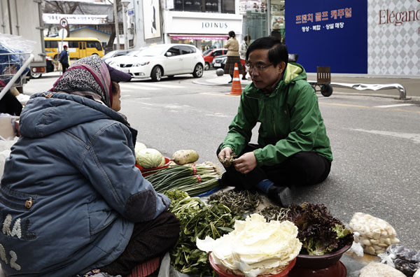 야채를 파는 할머니와 길바닥에 앉아서 이야기하는 박영화 예비후보