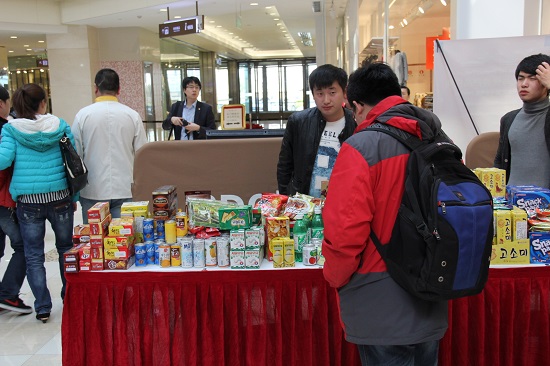 한 중국 현지인이 한국 식품이 전시된 부스를 보고 있다.