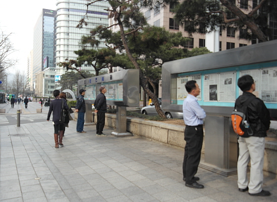 서울 프레스센터 앞 거리에서 시민들이 신문 벽보를 보고 있다. 오늘(10일)은 전국이 대체로 구름 많은 가운데 중서부 지방을 중심으로 낮 동안 연무 현상이 나타날 전망이다. 