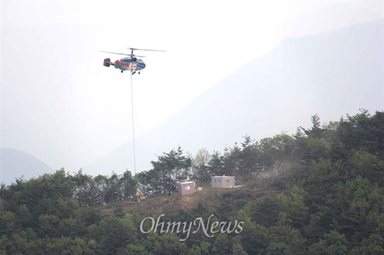 한국전력공사가 '신고리-북경남 765kV 송전선로' 100번 철탑 공사를 벌이고 있는 현장으로, 헬기를 통해 장비와 자재를 실어다 나르고 있다.