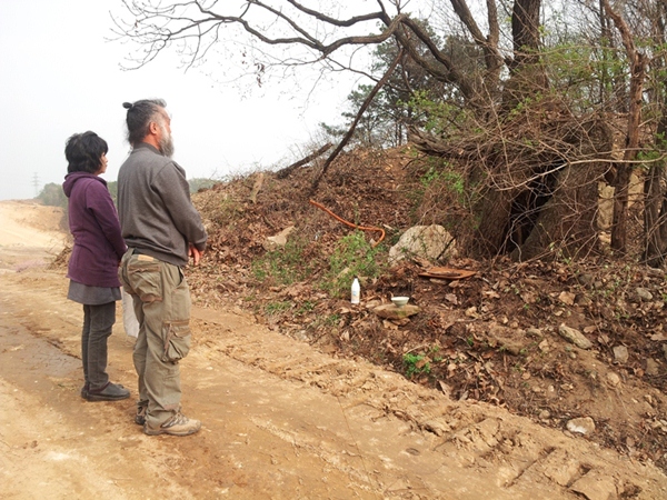 상교리에 거주하는 김원주 부부가 서낭할머니 나무 앞에 서 있다