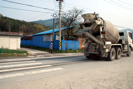  충남 공주시 반포면 송곡리 마을 입구에 행단보도가 있지만, 과속으로 달리는 레미콘 차량으로 인해 주민들은 늘 교통사고의 위험에 처해 있다. 그리고 도로에는 공장에서 날아온 시멘트와 돌가루 등으로 먼지가 가득했다. 
