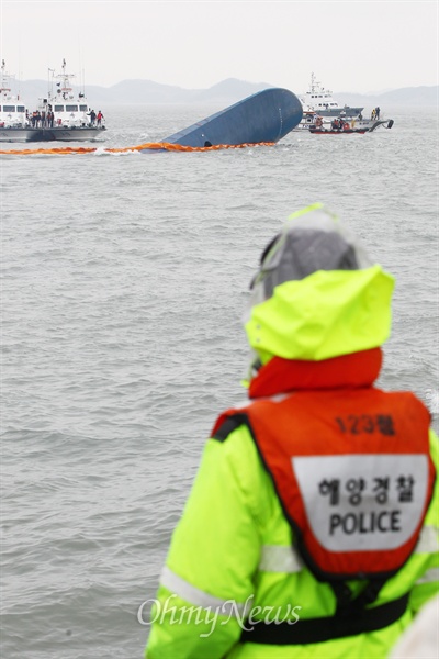 '세월호 침몰사건' 2일째를 맞았던 4월 17일 한 해양경찰이 선수만 보이는 세월호를 바라보고 있다. 
