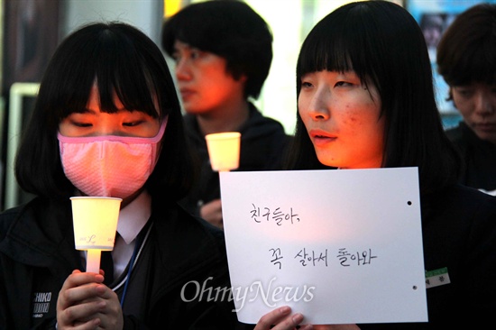  18일 저녁 창원 정우상가 앞에서 열린 '진도 해상 침몰 여객선 '세월호' 승객 무사생환 기원 촛불기도'에서 여고생들이 촛불을 들고 서 있다.