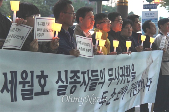 18일 저녁 창원 정우상가 앞에서 열린 '진도 해상 침몰 여객선 '세월호' 승객 무사생환 기원 촛불기도'에서 시민들이 촛불을 들고 서 있다.
