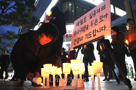 18일 저녁 창원 정우상가 앞에서 열린 '진도 해상 침몰 여객선 '세월호' 승객 무사생환 기원 촛불기도'에서 시민들이 촛불을 들고 서 있다.