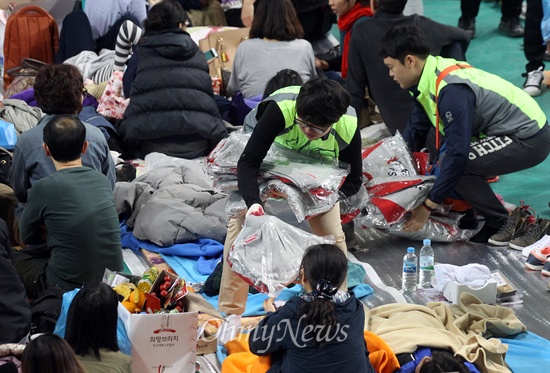 '세월호 침몰사건' 나흘째인 4월 19일 오전 전남 진도군 진도체육관에서 자원봉사자들이 실종자 가족들에게 구호물품을 나눠주고 있다.