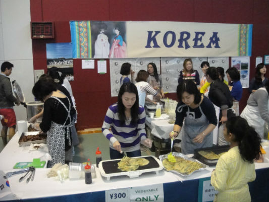 　　한국 학부모들이 부침개와 구운 고기를 팔기 위해서 준비하고 있습니다. 