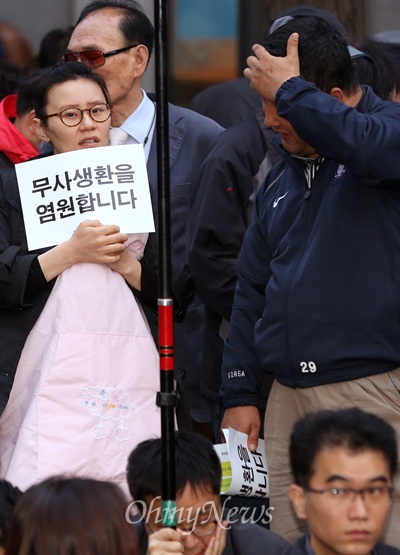 300여개 시민사회단체로 구성된 국정원시국회의가 19일 저녁 서울 종로구 청계광장에서 4·19 54주년을 기념한 범국민대회를 열었다. 이날 대회 참가자들은 "4·19 혁명이 일어난 날을 맞아 여러가지 목소리가 표현돼야 할 날이지만 세월호 침몰 피해자들의 무사생환을 염원하는 마음이 무엇보다도 우선"이라고 목소리를 높였다. 어린 아이를 안고있는 한 엄마도 사고 피해자들의 무사생환을 염원하며 이날 대회에 참여하고 있다.