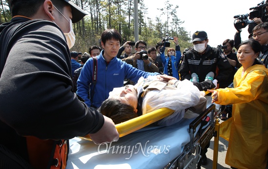 '세월호 침몰사고' 5일째인 20일 오전 전남 진도군 군내면에서 경찰이 세월호 침몰사고 피해자 가족의 행진을 저지하자, 이에 분노한 한 실종자 가족이 실신해 구급차로 이송되고 있다. 이날 세월호 실종자 가족들은 정부의 무기력한 대응에 더 이상 지켜볼 수 없다며 청와대 행진을 계획했다.