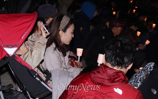 20일 저녁 경기 안산시 초지동 화랑유원지 원형 광장에서 안산지역 시민과 학생들이 여객선 세월호 침몰사고 실종자들의 무사 귀환을 기원하며 촛불을 들었다. 유모차를 탄 한 어린아이가 엄마 휴대폰으로 이 광경을 담고 있다.