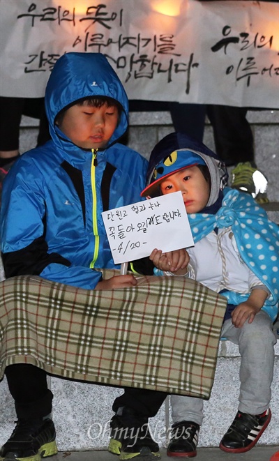 20일 저녁 경기 안산시 초지동 화랑유원지 원형 광장에서 안산지역 시민과 학생들이 여객선 세월호 침몰사고 실종자들의 무사 귀환을 기원하며 촛불을 밝혔다. 부모와 함께 이날 광장을 찾은 어린 아이들도 "단원고 형아 누나, 꼭 돌아오길 기도합니다"라고 손수 적은 편지를 꺼내들고 있다. 