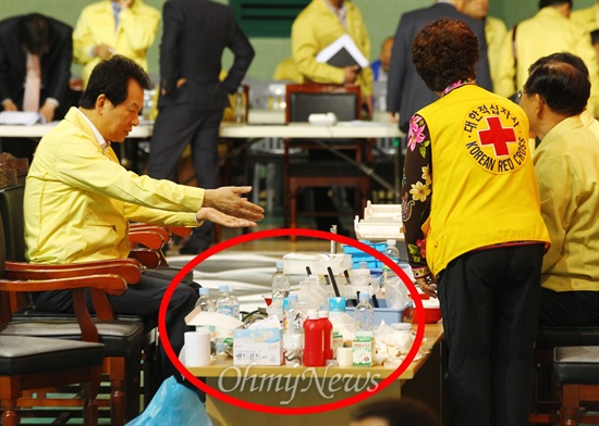 전남 진도해상에서 여객선 세월호 침몰사고가 일어난 16일 당일 구조된 탑승객들의 임시 보호소로 쓰인 진도 실내체육관을 방문한 서남수 교육부 장관이 의자에 앉아 컵라면이 익기를 기다리고 있다. 컵라면이 놓인 테이블 위로 어지럽게 놓여있는 의약품들이 보인다. 서 장관이 도착하기 직전까지 이 자리는 구조된 탑승객들의 응급처치와 진료가 이뤄졌던 곳이다. 