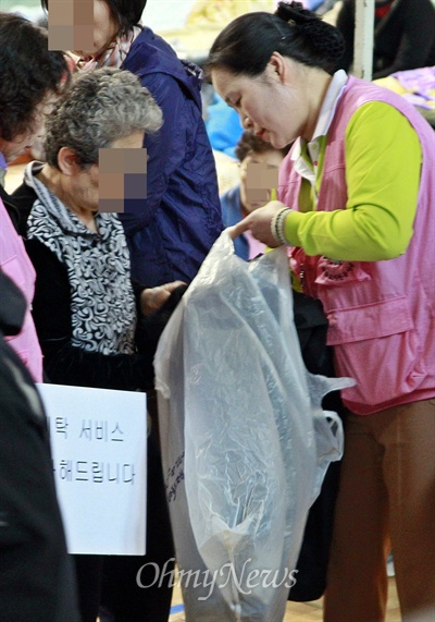 세탁 자원봉사자가 21일 진도군실내체육관을 돌며 세탁물을 거두고 있다.