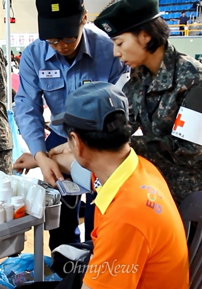 의료 지원을 나온 군인이 21일 진도군실내체육관에서 한 실종자 가족의 혈압을 재고 있다.